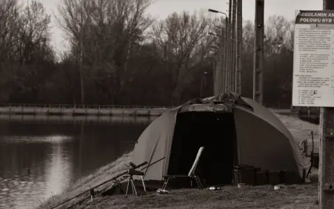 Namiot i sprzęt wędkarski nad jeziorem, idealne miejsce na kemping Polska.