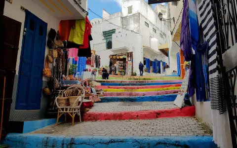 Bunte Treppe in Tanger, wo Frauen in bunten Gewändern Souvenirs verkaufen.