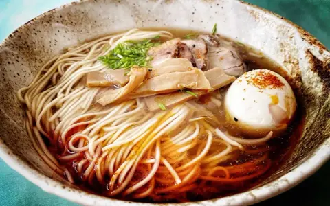 Miseczka aromatycznego ramenu z makaronem, jajkiem, mięsem i bambusem. Idealny przepis, jak zrobić ramen.