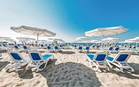Plaża w Voya Beach Resort Bułgaria, rzędy leżaków i parasoli czekają na gości.