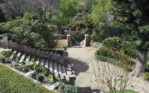 Steintreppen und üppige Vegetation in einem botanischen Garten mit Blick auf Lissabon.