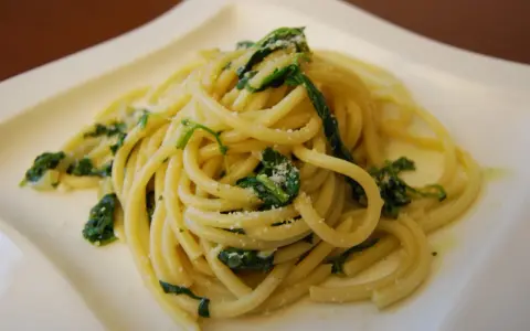Bucatini z zielonymi liśćmi i parmezanem, pyszne danie, które może konkurować ze spaghetti.