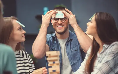 Amigos jugando a "adivina la palabra" en su frente, parte de juegos para fiestas adultos.