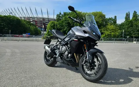 Szary motocykl Triumph Tiger Sport 660, gotowy do jazdy. Dane techniczne tego modelu zachwycają.