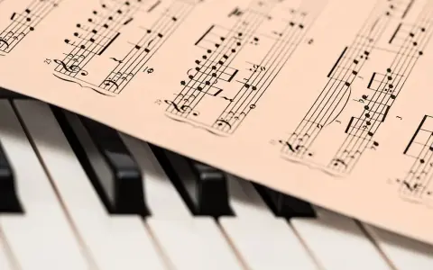 Partytura z nutami na klawiaturze pianina, gotowa do zagrania najsłynniejsze utwory jazzowe.