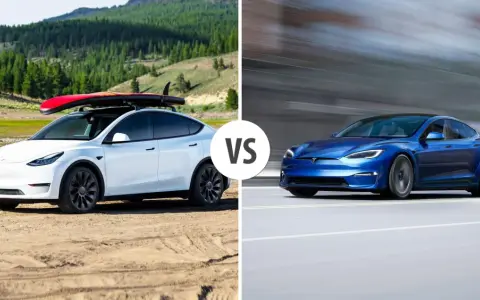 Biały Tesla Model Y z deską surfingową na dachu i niebieski Tesla Model S w ruchu.