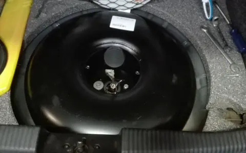 Przygotowania do wymiany butli LPG samemu. Widać narzędzia i pustą butlę w bagażniku.
