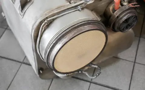 Element układu wydechowego, prawdopodobnie filtr DPF, gotowy do wypalania. Widoczny ceramiczny wkład.