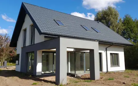 Nowoczesny dom 120 m² z szarym dachem i dużymi oknami. Zastanawiasz się, jaki koszt budowy domu 120 m²?