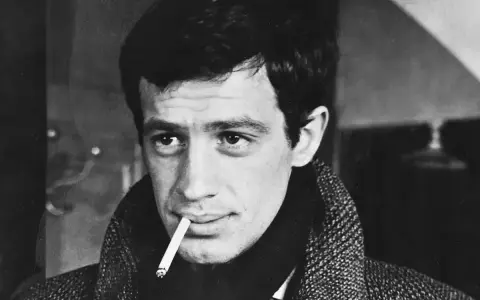 Jean-Paul Belmondo, z papierosem w ustach, w płaszczu, jakby właśnie wysiadł z pociągu do Gdyni.