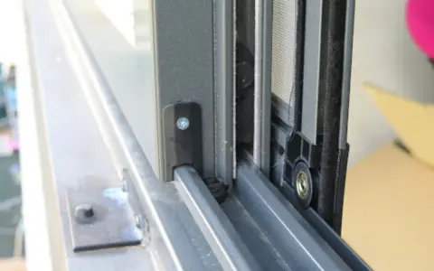 Detalle de cómo hacer una mosquitera corredera: el marco de aluminio y la malla en un riel.