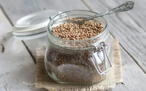 Un bocal en verre rempli de sarrasin, prêt à être cuisiné. C'est quoi le sarrasin ? Une graine nutritive et polyvalente.