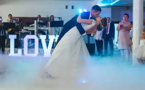 Para młoda tańczy do muzyki na weselu, otoczona mgłą i literami "LOVE". To jak scena z najsłynniejszych baletów.