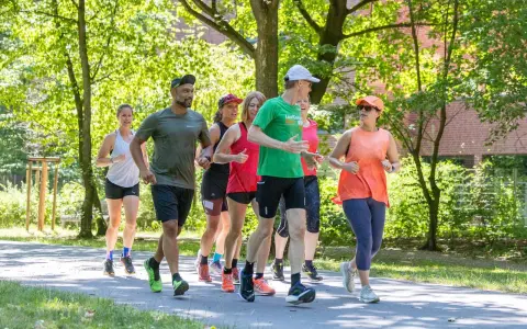 Eine Gruppe von Läufern genießt eine gemeinsame Trainingseinheit in Berlin. Die Laufgruppen Berlin sind aktiv und motiviert.