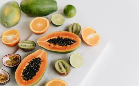 Kolorowe owoce: papaja, kiwi, pomarańcze, limonki i marakuja. Czy owoce tuczą? Te na zdjęciu wyglądają zdrowo i pysznie!