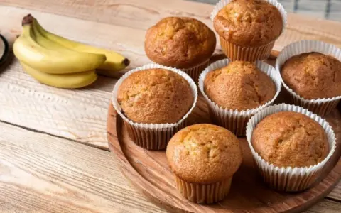 Puszyste babeczki z airfryer, pachnące bananami, ułożone na drewnianej desce.
