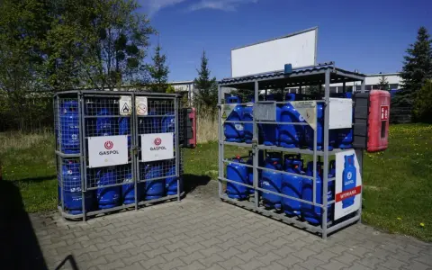 Butle z gazem Gaspol stoją w metalowych stojakach. Zastanawiasz się, ile kosztuje butla z gazem? Sprawdź cenę wymiany.