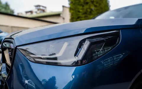 Błyszczący, niebieski lakier BMW z reflektorem LED. To właśnie autodetailing co to znaczy, że samochód wygląda jak nowy.