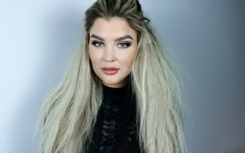 En kvinna med blå ögon och en snygg makeup har sitt blonda hår stylat med en våffla.