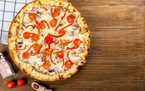 Apetyczna pizza z pomidorkami i papryką, idealna na wieczór. Czy zastanawiałeś się nad pizza hut kalorie?
