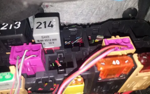 Skrzynka bezpieczników Audi A4 B5 z widocznymi przekaźnikami i kolorowymi bezpiecznikami.