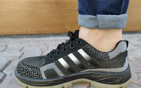 Czarne buty sportowe z białymi paskami i podwiniętymi nogawkami jeansów. Idealny przykład, jak podwinąć spodnie.