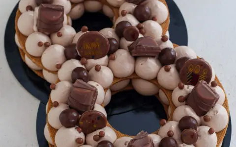 Gâteau number cake chocolat, décoré de crème onctueuse, de chocolats et de billes croquantes. Parfait pour une recette number cake chocolat d'anniversaire.