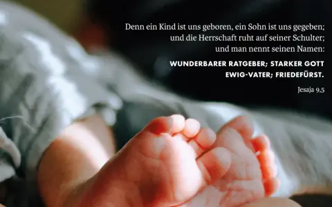 Zarte Füße eines Neugeborenen, umgeben von weichen Stoffen. Der Text zitiert Jesaja 9,5: "Wunderbarer Ratgeber, starker Gott, Ewig-Vater, Friedefürst.