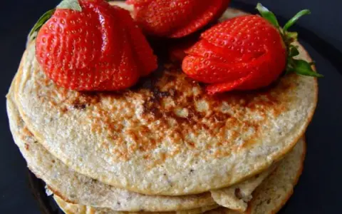 Deliciosas tortitas de avena y plátano, coronadas con fresas rojas y jugosas. Un desayuno perfecto.