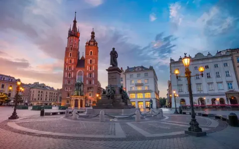 Kraków co warto zobaczyć: Rynek Główny z Kościołem Mariackim i pomnikiem Mickiewicza o zachodzie słońca.