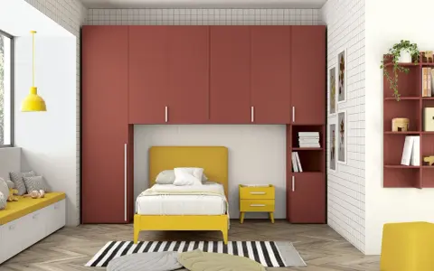 Soluzione perfetta per organizzare armadio a ponte bambini: letto giallo, armadi rossi e tanto spazio per giocare.