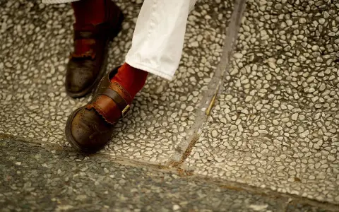 Scarpe marroni uomo con fibbia e calzini rossi, perfette per un look casual chic.