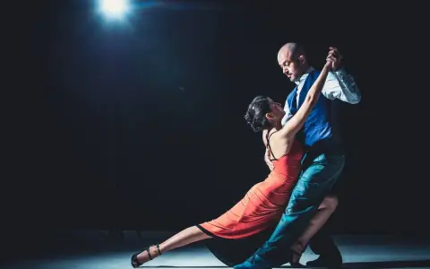 Para, w czerwonej sukni i mężczyzna w kamizelce, tańczą tango. "Taniec to krótki cytat o tańcu.