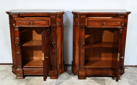 Paire de commodes en bois sombre, style mobilier Napoléon III, avec tiroirs et portes sculptées.