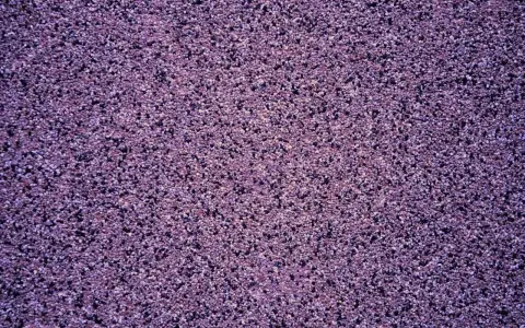 Fioletowy tynk mozaikowy o drobnej ziarnistości. Wydajność 25 kg na ok. 3-4 m², zależnie od grubości warstwy.