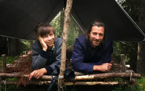 Markus Torgeby familj njuter av naturen under ett enkelt vindskydd i skogen.