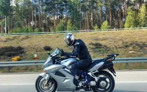 Motocyklista na srebrnej Hondzie VFR 800, mimo że to świetna maszyna, ma swoje wady. Jazda po lesie.