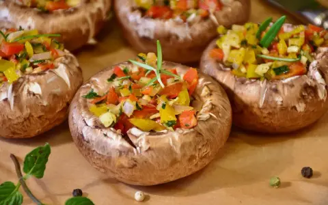 Champignons farcis aux poivrons colorés et herbes fraîches, prêts à être dégustés.