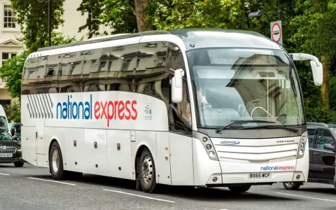 Biały autokar National Express na ulicy w Londynie, gotowy do podróży z Luton do centrum.