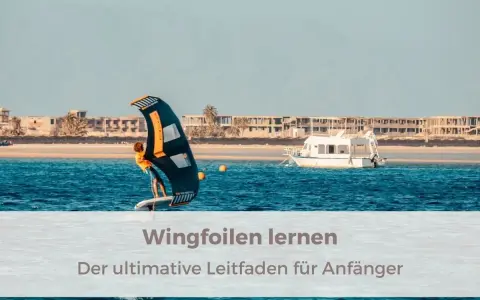 Person lernt wingfoilen auf dem Meer, mit einem Boot und Gebäuden im Hintergrund. Der ultimative Leitfaden für Anfänger.