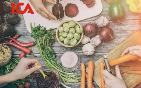 ICA-logotypen över en bild av färska grönsaker som förbereds för ett recept. Rödbetor skivas, morötter skalas och en skål med puré.