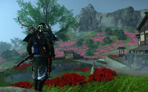 Samuraj w zbroi z łukiem na plecach stoi na tle kwitnącej wiśni. Sceneria z gry Ghost of Tsushima na Xbox.