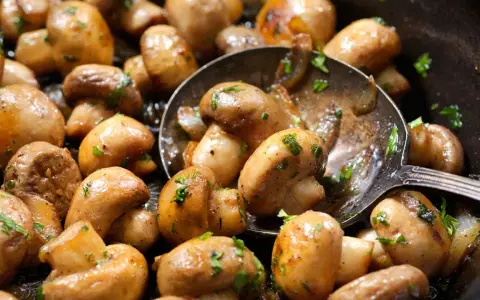 Champiñones salteados con perejil, perfectos para tus recetas con champiñones. Una cuchara sirve para probarlos.