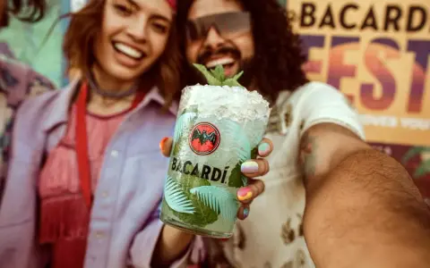 Radosna para świętuje na festiwalu z orzeźwiającym drinkiem Bacardi Mojito.