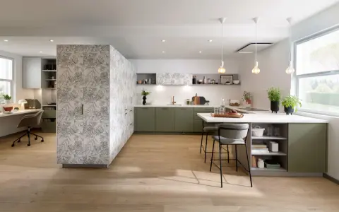 Cuisine moderne avec îlot central, murs décorés de motifs végétaux. Quel mur peindre en couleur ? Les meubles verts s'harmonisent avec le bois clair.