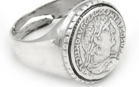 Anello in argento con moneta antica incisa, un pezzo unico che porta con sé storie di epoche passate.