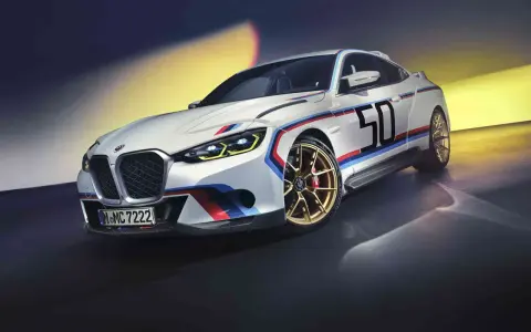 Sportlicher BMW 3.0 CSL in Weiß mit M-Streifen und der Startnummer 50 auf goldenen Felgen.