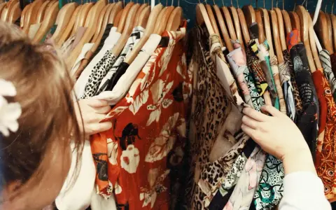 En person letar efter vilken stil har jag bland färgglada kläder med mönster som leopard och blommor.