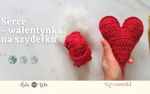 Czerwone serce na szydełku, gotowe na walentynki. Obok kłębek czerwonej włóczki i białe wypełnienie.