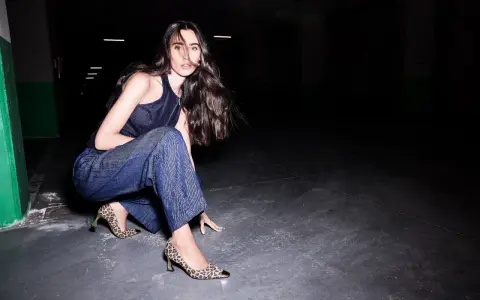 Donna con pantaloni larghi alla caviglia e décolleté leopardate. Un look audace per chi sa che scarpe mettere con pantaloni larghi alla caviglia.